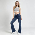 Woman wearing a striped crop top and blue jeans on a white background