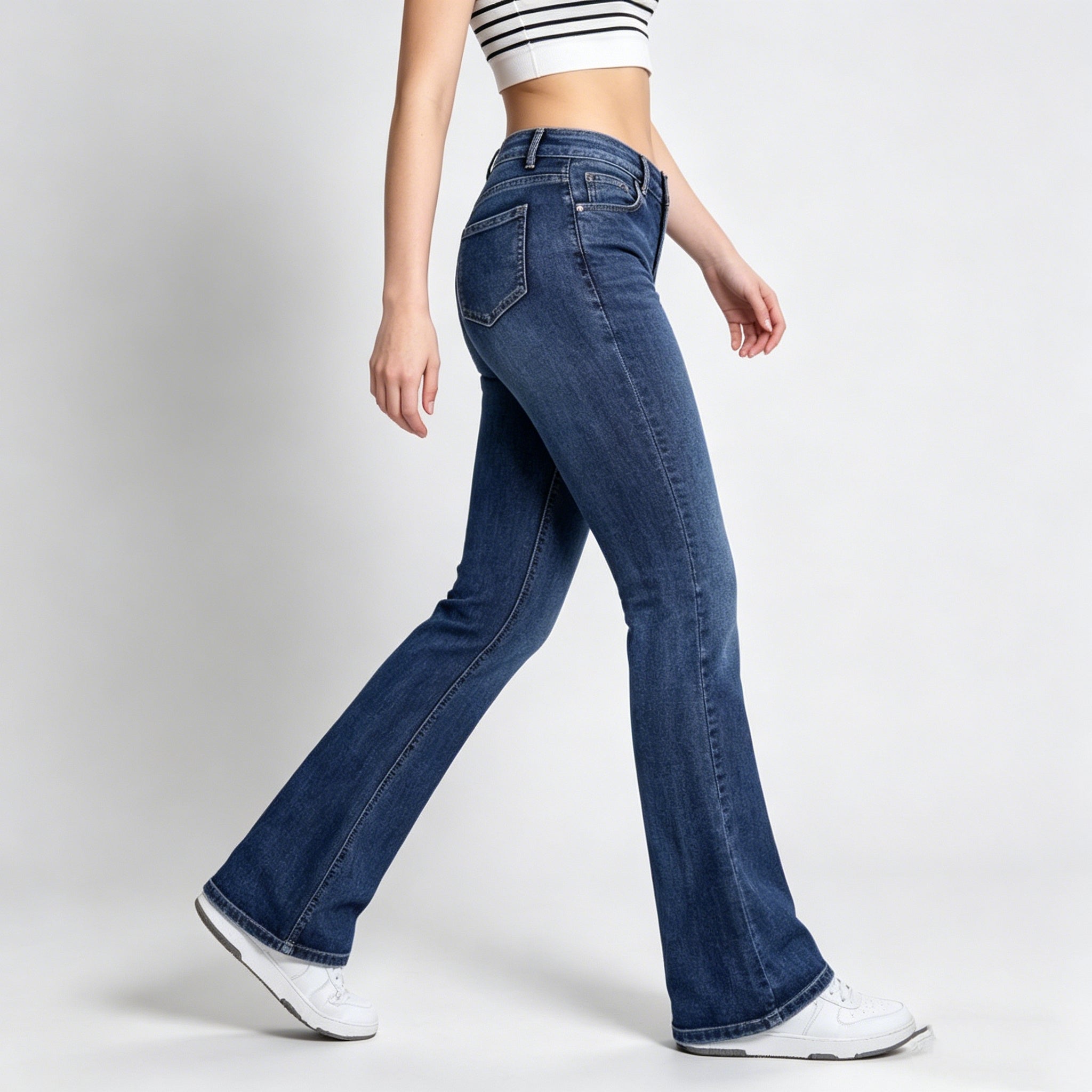 Person wearing blue flared jeans on a white background