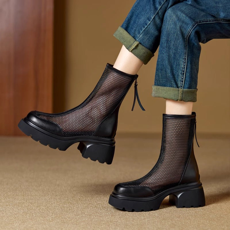 Black mesh boots worn with rolled-up jeans on a beige background