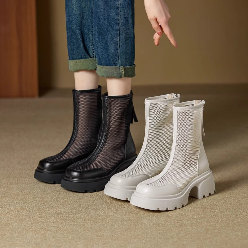 Black and white mesh boots on a neutral background