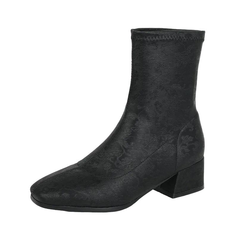 Black ankle boot with a block heel on a white background