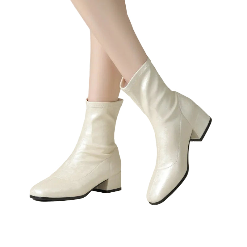 White ankle boots with a block heel on a neutral background