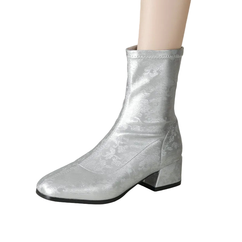 Silver metallic ankle boot on a white background