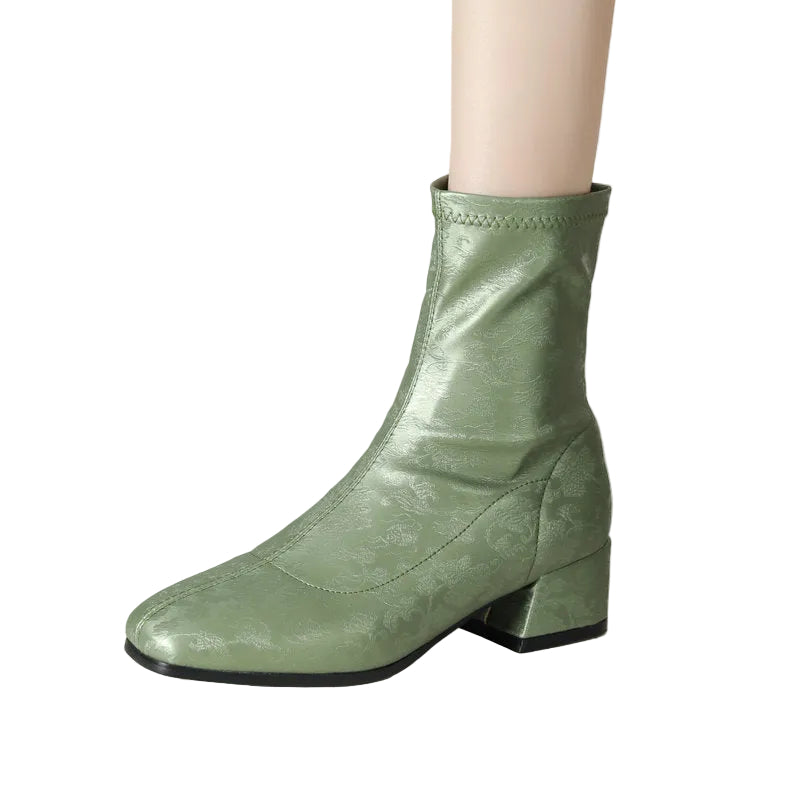 Green ankle boot on a neutral background