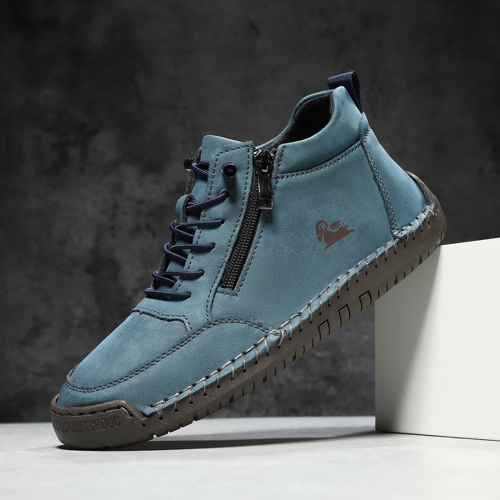 Blue leather shoe with a brown sole on a dark background