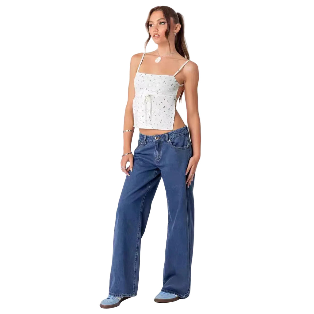 Woman wearing a white top and blue jeans on a light gray background