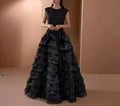 Woman wearing a black ruffled gown against a beige background