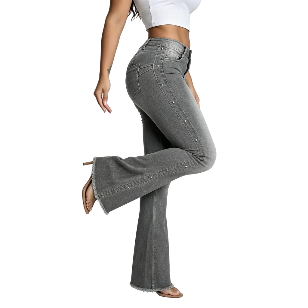 Person wearing gray flared jeans on a plain background