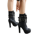 Black high-heeled boots with studded details on a neutral background