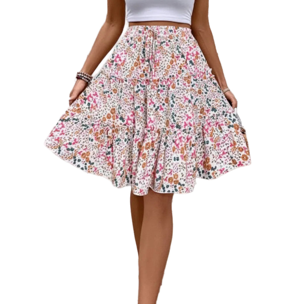 Person wearing a floral skirt and white top against a textured wall.