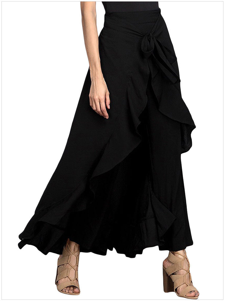 Black ruffled skirt worn by a person on a white background